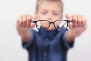 enfant flou tenant une paire de lunettes